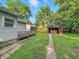 View of the home's backyard with green grass, detached garage, and shelter with chairs at 637 Olin Ave, Indianapolis, IN 46222