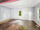 Bedroom with hardwood floor, unfinished wall repair, and windows with natural light at 637 Olin Ave, Indianapolis, IN 46222