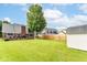 Large, grassy backyard with a deck, mature tree, shed, and fencing, creating a private outdoor space at 662 Leah Way, Greenwood, IN 46142