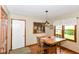 A dining area features a wood table and chairs, a floral window valance, and an artistic wall hanging of wine at 662 Leah Way, Greenwood, IN 46142