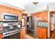 A kitchen features stainless appliances, a black granite counter, wood cabinets and mosaic backsplash and a view of the living area at 662 Leah Way, Greenwood, IN 46142