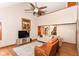 The well-lit living room features a sofa, an oversized chair, a fan and a view of the stairway to the second floor at 662 Leah Way, Greenwood, IN 46142