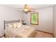 Warm bedroom with natural lighting, metal bedframe, ceiling fan, and beige walls at 662 Leah Way, Greenwood, IN 46142