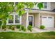 Close up of the front entrance of a stone accented home, framed by lush landscaping at 7147 Prelude Rd, Brownsburg, IN 46112