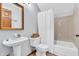 Bathroom features a pedestal sink, gold-framed mirror, and a shower-tub combination at 7304 E Stop 11 Rd, Indianapolis, IN 46259