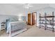 Bright bedroom with neutral carpet, light blue walls, and decorative shelving at 7304 E Stop 11 Rd, Indianapolis, IN 46259