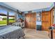 Bedroom with wood floors, lots of light and glass doors that lead to a lovely view of the outdoors at 7304 E Stop 11 Rd, Indianapolis, IN 46259