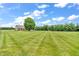 Well-maintained lawn with mature tree leading up to a charming single Gathering home on a sunny day at 7304 E Stop 11 Rd, Indianapolis, IN 46259