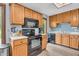Well-equipped kitchen featuring wood cabinetry and modern black appliances at 7304 E Stop 11 Rd, Indianapolis, IN 46259