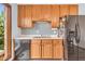 Functional kitchen with classic wood cabinets, black appliances, and a view of the yard at 7304 E Stop 11 Rd, Indianapolis, IN 46259