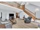 Spacious living area with beautiful wood floors, staircase, and a comfortable leather sofa at 7304 E Stop 11 Rd, Indianapolis, IN 46259