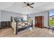 Spacious main bedroom with natural light, ceiling fan and wooden floors offers a calm retreat at 7304 E Stop 11 Rd, Indianapolis, IN 46259