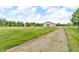 Large outbuilding with a gravel driveway and well-maintained lawn on a sunny day at 7304 E Stop 11 Rd, Indianapolis, IN 46259