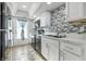 Modern kitchen featuring white cabinets, black appliances, and stylish backsplash at 7468 Countrybrook Dr, Indianapolis, IN 46260