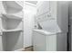 Efficient laundry room with stacked washer/dryer and built-in shelves at 7468 Countrybrook Dr, Indianapolis, IN 46260