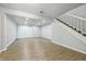 Large living room with wood flooring, a brick accent wall, recessed lights, and stairs at 7468 Countrybrook Dr, Indianapolis, IN 46260