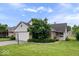 Charming home with a well-maintained lawn, mature tree, and a two-car garage during a bright day at 8213 Thoroughbred Run, Indianapolis, IN 46256