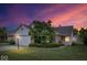 Charming home with a well-maintained lawn, mature tree, and a two-car garage under a colorful, vibrant sky at 8213 Thoroughbred Run, Indianapolis, IN 46256
