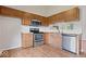 Functional kitchen with wood cabinets, stainless steel appliances, and wood laminate flooring for easy cleaning at 8213 Thoroughbred Run, Indianapolis, IN 46256