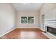Bright living room featuring wood flooring, a white fireplace, and large windows offering outdoor views at 8213 Thoroughbred Run, Indianapolis, IN 46256