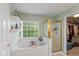 Bright bathroom featuring a soaking tub, walk in closet, and a glass shower at 8336 Bent Oak Dr, Indianapolis, IN 46236