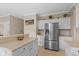 Bright kitchen showcases stainless steel refrigerator, bar seating, and white cabinets for ample storage at 8336 Bent Oak Dr, Indianapolis, IN 46236