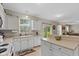Well-lit kitchen features white cabinetry, a breakfast bar, and views into the living room and backyard at 8336 Bent Oak Dr, Indianapolis, IN 46236