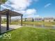 Scenic backyard view features a pergola and serene pond, enhancing the property's appeal and outdoor living space at 8866 Twain Ln, Indianapolis, IN 46239