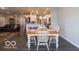 Cozy dining area with white chairs and modern lighting, open to the living room and kitchen at 8866 Twain Ln, Indianapolis, IN 46239