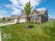 A home with a lush green lawn and beautiful landscaping create a welcoming outdoor space at 8866 Twain Ln, Indianapolis, IN 46239