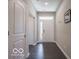Well-lit hallway with hardwood floors, leading to multiple rooms and offering a glimpse of natural light at 8866 Twain Ln, Indianapolis, IN 46239