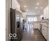 Well-lit kitchen featuring white cabinets, stainless steel appliances, and an open layout to dining area at 8866 Twain Ln, Indianapolis, IN 46239