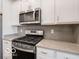 Close up of stainless steel gas range and microwave above with matching light countertops at 8866 Twain Ln, Indianapolis, IN 46239