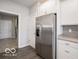 Bright kitchen featuring stainless steel refrigerator, white cabinets, and granite countertops at 8866 Twain Ln, Indianapolis, IN 46239