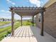 Backyard patio features a pergola with view of lawn and community pond, perfect for relaxation and gatherings at 8866 Twain Ln, Indianapolis, IN 46239