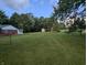 Expansive backyard with lush lawn, mature trees, and outbuildings; perfect for outdoor activities at 8923 Maze Rd, Indianapolis, IN 46259