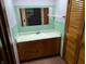 Bathroom with green tile, a wooden vanity, and a mirror at 8923 Maze Rd, Indianapolis, IN 46259