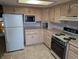 Traditional kitchen featuring linoleum flooring, neutral-colored cabinets, and standard appliances at 8923 Maze Rd, Indianapolis, IN 46259