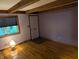 Cozy living room featuring hardwood floors, a window with blinds, and wooden ceiling beams at 8923 Maze Rd, Indianapolis, IN 46259