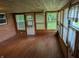 Enclosed sunroom featuring wood paneled walls and ceiling, plenty of natural light, and hardwood floors at 8923 Maze Rd, Indianapolis, IN 46259