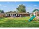 Backyard with a playset, outdoor grill, wood deck with patio seating, and a brick house exterior at 911 Glendale Dr, Lebanon, IN 46052