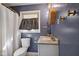 Stylish bathroom featuring modern fixtures, a window above the toilet and blue painted walls at 911 Glendale Dr, Lebanon, IN 46052