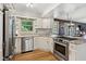 A bright kitchen featuring stainless steel appliances, granite countertops, and white cabinetry at 911 Glendale Dr, Lebanon, IN 46052