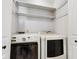 Functional laundry area with modern white washer and dryer, and decorative wallpaper at 911 Glendale Dr, Lebanon, IN 46052