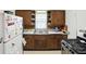 Functional kitchen with rustic cabinetry, brick backsplash, and modern appliances for a charming cooking space at 95 S 11Th Ave, Beech Grove, IN 46107