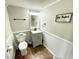 Half bathroom features a neutral color scheme, vanity with sink, and humorous decorative wall art at 9628 Gull Lake Dr, Indianapolis, IN 46239