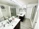 Spacious bathroom with dual sinks, a large mirror, updated flooring, and a glass-enclosed shower stall at 9628 Gull Lake Dr, Indianapolis, IN 46239
