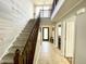 Bright foyer featuring tile floors, a staircase with wood banister, a high ceiling, and natural light from a transom window at 9628 Gull Lake Dr, Indianapolis, IN 46239