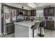 Spacious kitchen with stainless steel refrigerator, center island with seating, and dark wood cabinets at 9628 Gull Lake Dr, Indianapolis, IN 46239