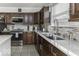 Updated kitchen featuring stainless steel appliances, marble countertops, mosaic tile backsplash, and dark wood cabinets at 9628 Gull Lake Dr, Indianapolis, IN 46239